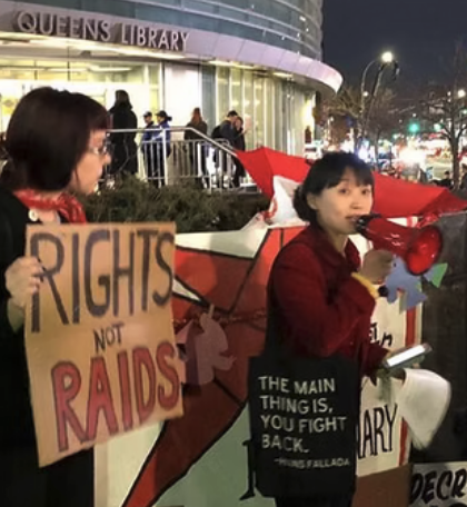 Kaitlin Cort speaking at a rally with a Rights Not Raids sign in the background